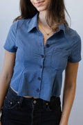 Woman wearing a blue checkered shirt against a plain background