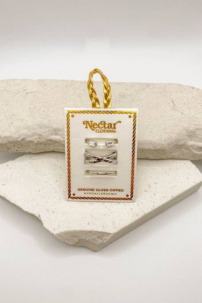 Nectar Clothing jewelry tag with silver earrings on a stone surface