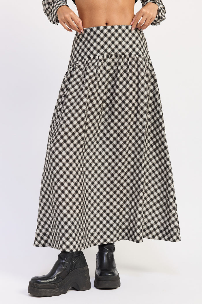 A black and white gingham checkered midi skirt worn by a model, paired with black platform ankle boots against a plain white studio background.