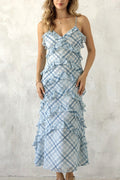 Woman wearing a blue and white plaid dress against a light background