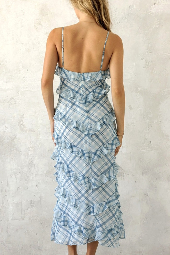 Woman wearing a blue patterned dress against a light gray background