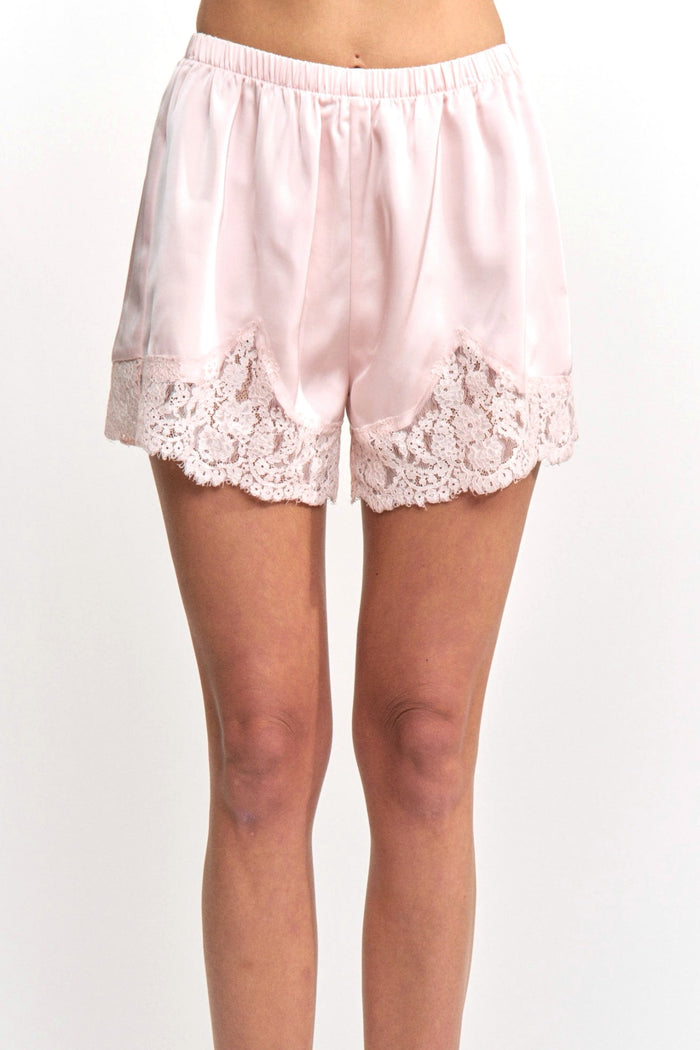 Pink satin shorts with lace trim on a white background