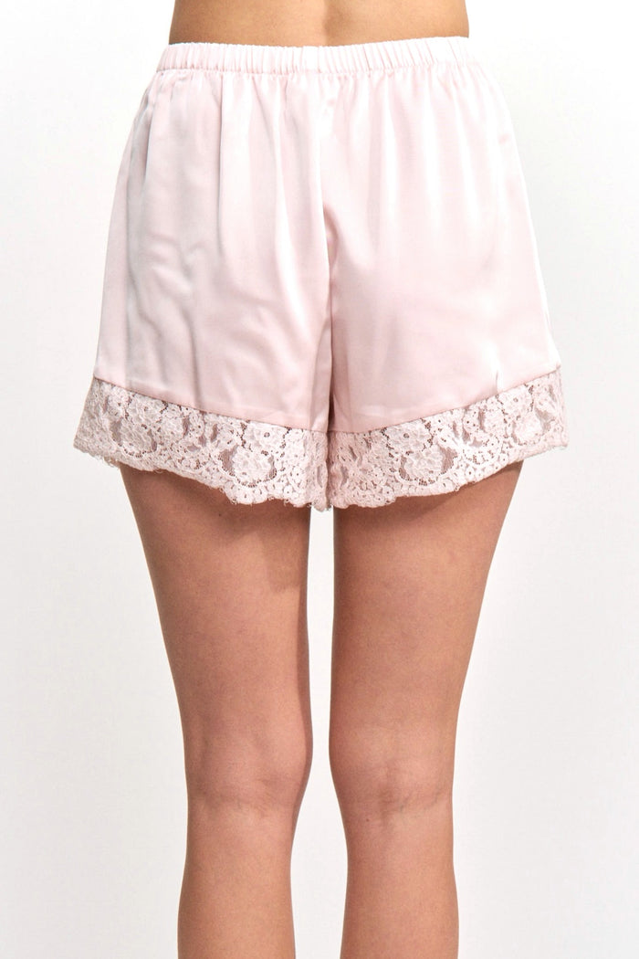 Light pink satin shorts with lace trim on a white background