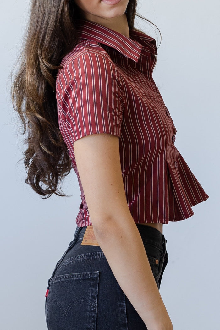 Woman wearing a red and white striped shirt against a plain background