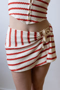 Red and white striped crochet top and skirt set on a plain background